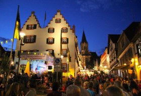 Belebter Marktplatz mit historischen Fachwerkh&auml;usern und festlicher Beleuchtung bei Nacht