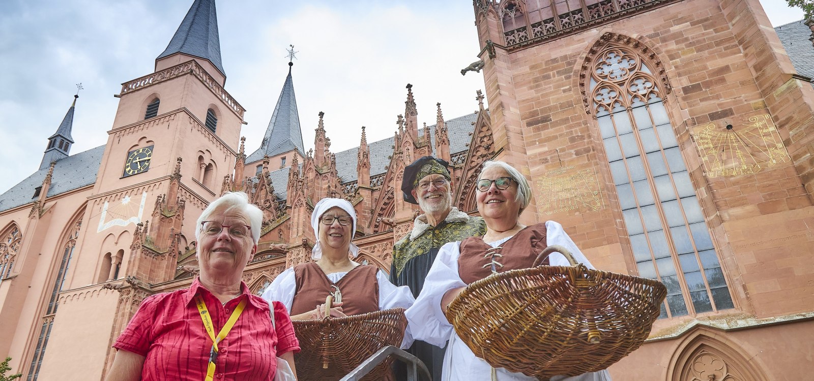 Eine Gruppe aus G&auml;stebegleitern steht vor einer Kirche