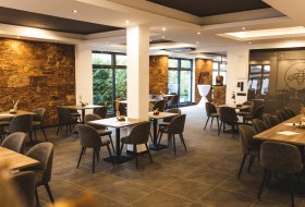 Das Bild zeigt einen eleganten Raum mit St&uuml;hlen und Tischen, perfekt f&uuml;r eine Weinprobe. &copy; Weingut am Honigberg