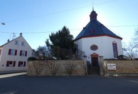Achteckige Kirche, umgeben von einer niedrigen Steinmauer
