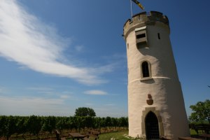 Wei&szlig;er Rundturm im Weinberg vor blauem Himmel