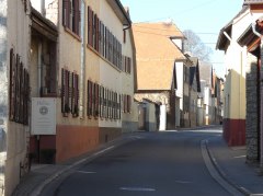 Enge Straße mit alten Häusern und Holzläden in einem ruhigen Dorf