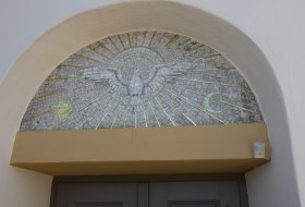 Mosaik &uuml;ber einer T&uuml;r mit einem Adler, der von Sonnenstrahlen umgeben ist, und zwei Halbmondsymbolen.