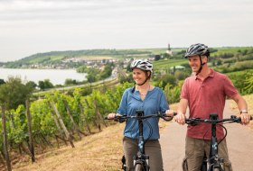 Ein Paar fährt mit dem Fahrrad durch die Weinberge. © Dominik Ketz, Rheinhessen-Touristik GmbH