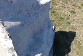 Gedenkstein mit eingraviertem Text &uuml;ber den Ort der Senckenberg-Grabung auf einer Wiese