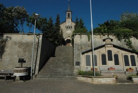 Steintreppe f&uuml;hrt zu einer kleinen Kirche, daneben Gedenktafeln an der Wand