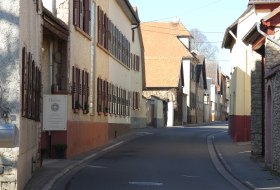 Enge Stra&szlig;e mit alten H&auml;usern und Holzl&auml;den in einem ruhigen Dorf